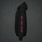 A black pullover hoodie shown from the side profile on a solid white background, featuring vertical pink text on the right sleeve reading 'RISE • IGNITE • REDLINE'.